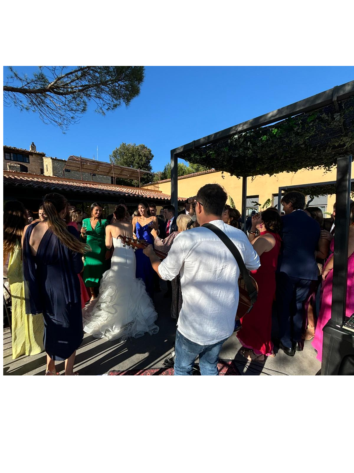 Joan Tena tocando la guitarra en directo en una boda, rodeado de invitados