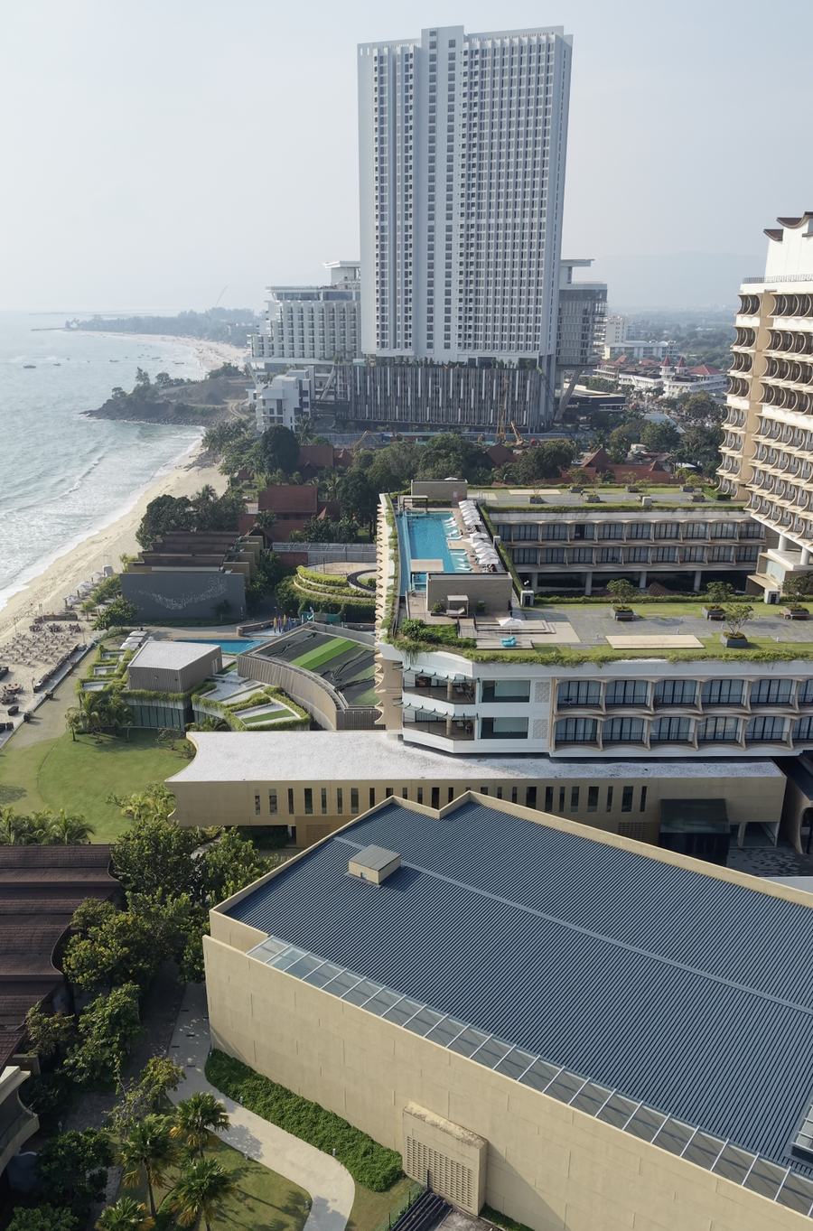 Parkroyal Langkawi Resort in the foreground along Pantai Chenang, with Tropicana's completed tower and the still-unfinished Hilton Nautilus rising behind it