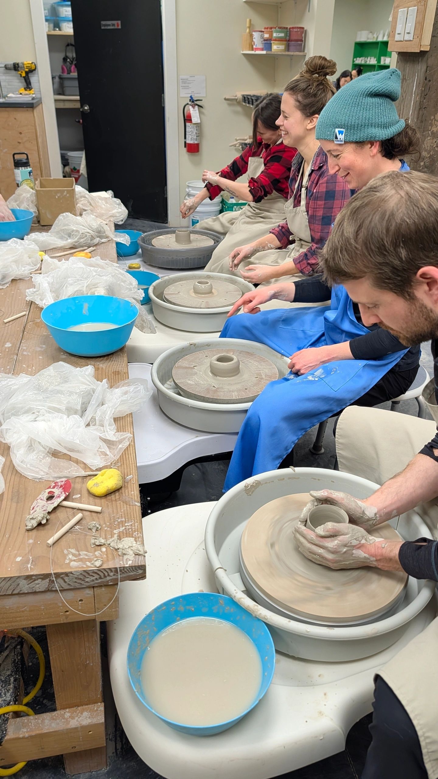 Students working at pottery wheels during a class at South Side Arts