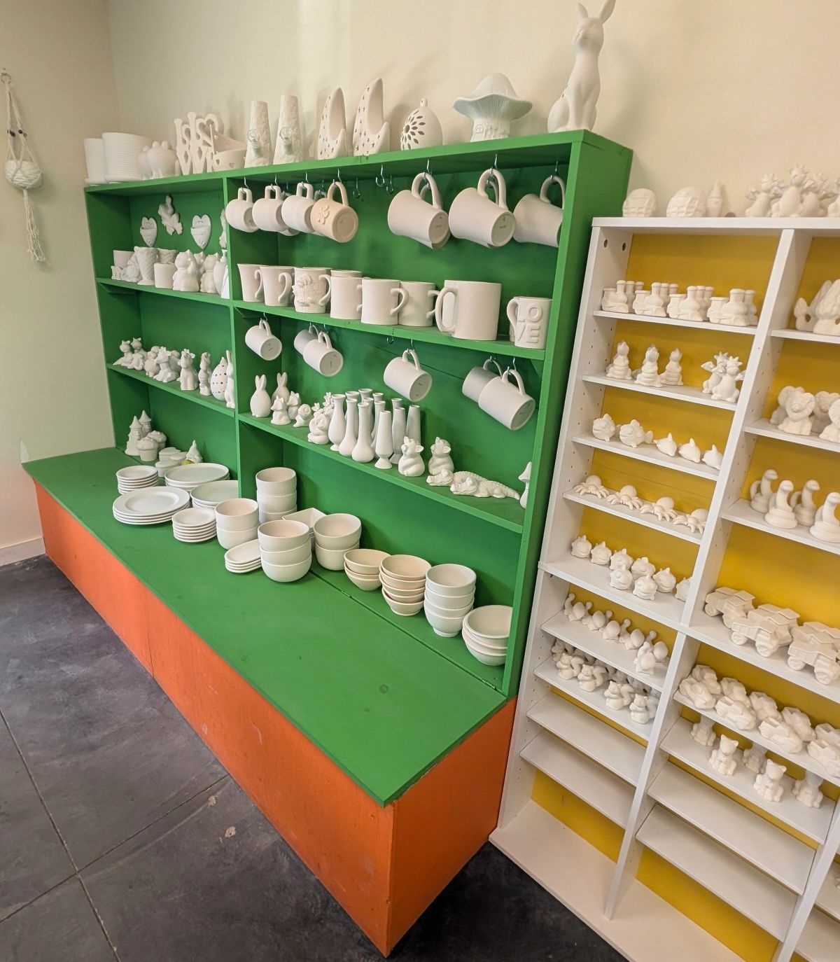 Shelves full of white ceramic pieces ready to be painted