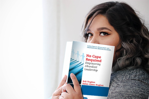 A reader peeking over the cover of No Cape Required