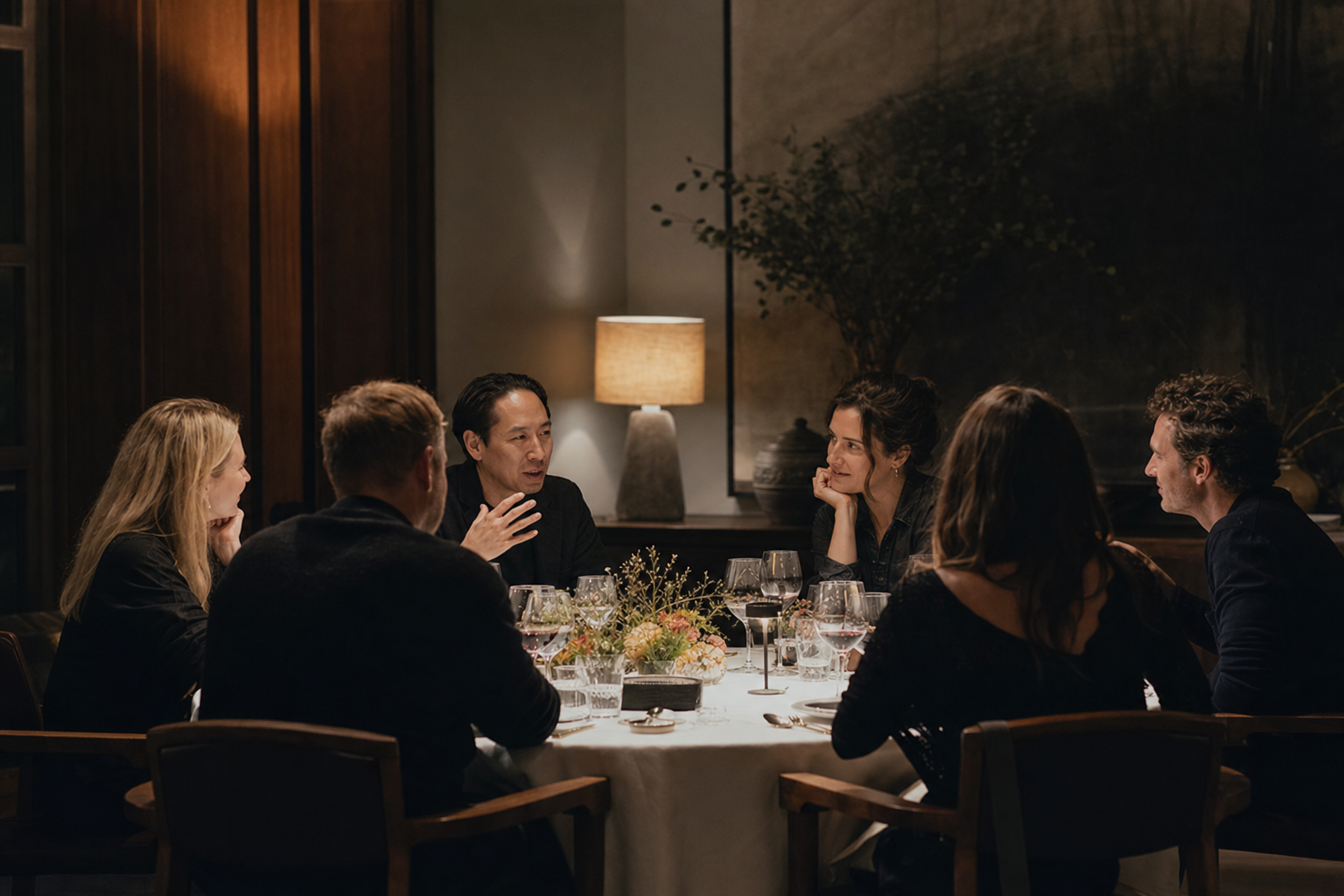 Guests seated around a candlelit dinner table in Marbella